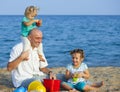 Happy girls with dad on sea shore Royalty Free Stock Photo