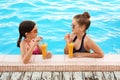 Happy girls with drinks in pool