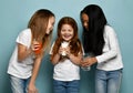 Happy girls friends children in white t-shirts with text space standing and holding water, milk or kefir and fresh