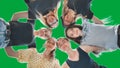 Happy girls friends hugging in a circle on a green background. Royalty Free Stock Photo