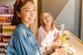 Happy girls having lunch in a cafe, drinking coffe and talking. Friendship and lifestyle concept Royalty Free Stock Photo