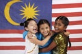 Happy girls hugging each other with Malaysian flag in the background. Conceptual image