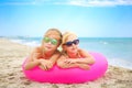 Happy girls lying on pink inflatable circle