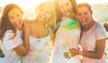 Happy girls making party at holi colors festival in summer time - Young women friends having fun on the beach musi event at sunset Royalty Free Stock Photo