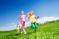 Happy girls and other kids running in green field Royalty Free Stock Photo