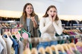 Happy girls pointing finger at new clothes in clothing store Royalty Free Stock Photo