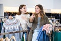 Happy girls pointing finger at new clothes in clothing store Royalty Free Stock Photo