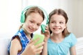 Happy girls with smartphone and headphones Royalty Free Stock Photo