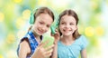 Happy girls with smartphone and headphones Royalty Free Stock Photo