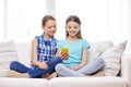 Happy girls with smartphone sitting on sofa