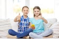 Happy girls with smartphone sitting on sofa