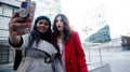 Happy girls taking a photo surprised outdoors