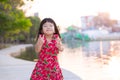 Happy girls for walk in park in evening. Child raises two fingers with two of her hands. Cute kid sweet smile, wrinkled neck.