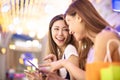 Girls watching phone in the shopping mall Royalty Free Stock Photo