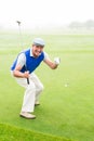 Happy golfer cheering on putting green Royalty Free Stock Photo