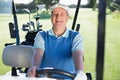 Happy golfer driving his golf buggy smiling at camera Royalty Free Stock Photo