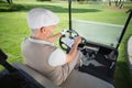 Happy golfer driving his golf buggy Royalty Free Stock Photo