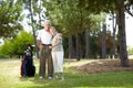 Happy Golfers. Full-length portrait of a happy senior couple standing with a bag of golf clubs on a golf course. Royalty Free Stock Photo