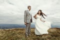 Happy gorgeous bride and groom holding hands and dancing in sun Royalty Free Stock Photo