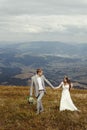 Happy gorgeous bride and groom walking in sun light, boho weddi Royalty Free Stock Photo