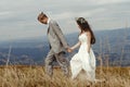 Happy gorgeous bride and groom walking in sun light holding han Royalty Free Stock Photo