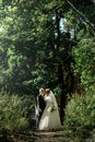 Happy gorgeous bride and stylish groom holding hands and walking Royalty Free Stock Photo