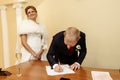 Happy gorgeous bride and stylish groom signing official document Royalty Free Stock Photo