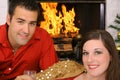 Happy gorgeous couple in front of fireplace