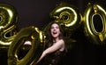 Happy gorgeous girl in stylish sexy party dress holding gold 2020 balloons, having fun at New Year`s Eve Party Royalty Free Stock Photo