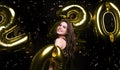 Happy gorgeous girl in stylish sexy party dress holding gold 2020 balloons, having fun at New Year`s Eve Party Royalty Free Stock Photo