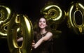 Happy gorgeous girl in stylish sexy party dress holding gold 2020 balloons, having fun at New Year`s Eve Party Royalty Free Stock Photo