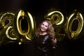 Happy gorgeous girl in stylish sexy party dress holding gold 2020 balloons, having fun at New Year`s Eve Party Royalty Free Stock Photo