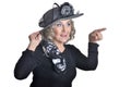 Happy gorgeous mature woman in hat showing something