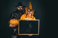 Happy gothic couple in Halloween costume. Jack-o-lanterns. Halloween poster or greeting card - people concept.