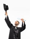 Happy graduate in black toga holding up his hat