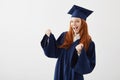 Happy graduate girl in mantle rejoicing laughing smiling over white background.