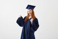 Happy graduate girl in mantle rejoicing laughing smiling over white background.