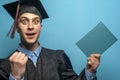 Happy Graduate man holding up a diploma