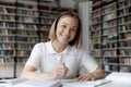 Happy graduate student girl in headphones writing notes Royalty Free Stock Photo