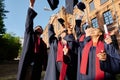 Happy graduated students standing outdoors Royalty Free Stock Photo