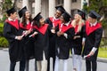 Happy graduates in graduation costumes chatting during ceremony Royalty Free Stock Photo