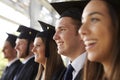 Happy graduates in mortars and gowns, head and shoulders