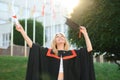 Happy graduation day for a young woman very beautiful with graduation cap smile large, while holding her diploma Royalty Free Stock Photo