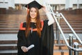 Happy graduation day for a young woman very beautiful with graduation cap smile large in front of the Camera posing Royalty Free Stock Photo