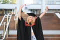 Happy graduation day for a young woman very beautiful with graduation cap smile large, while holding her diploma Royalty Free Stock Photo