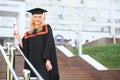 Happy graduation day for a young woman very beautiful with graduation cap smile large, while holding her diploma Royalty Free Stock Photo