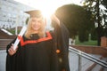 Happy graduation day for a young woman very beautiful with graduation cap smile large, while holding her diploma Royalty Free Stock Photo