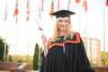 Happy graduation day for a young woman very beautiful with graduation cap smile large, while holding her diploma Royalty Free Stock Photo