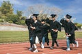 Happy graduation students  holding diploma and running on the stadium at school Royalty Free Stock Photo