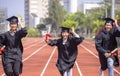 Happy graduation students  holding diploma and running on the stadium at school Royalty Free Stock Photo